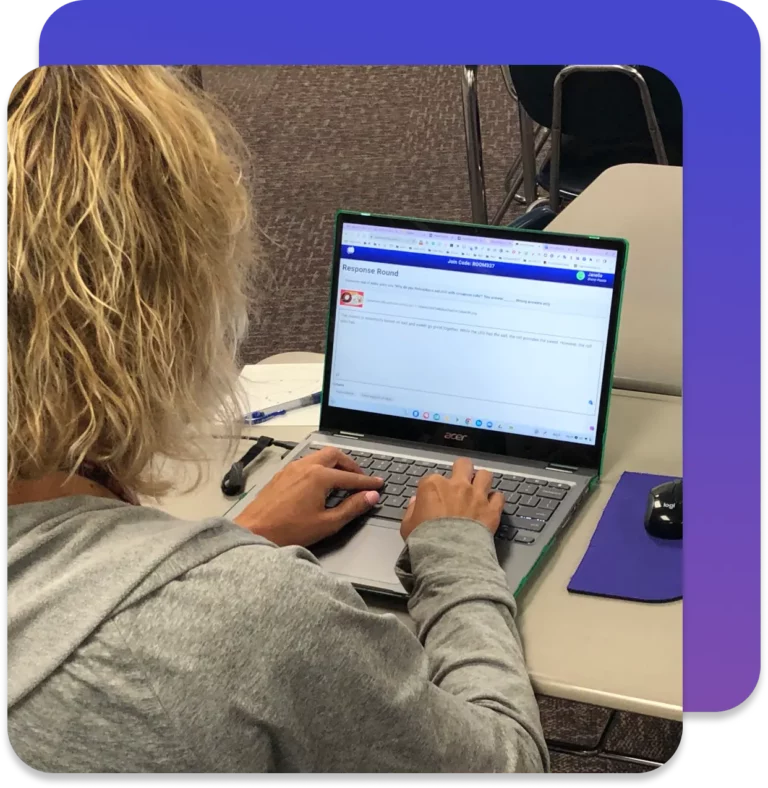 Teacher typing at a computer using Short Answer