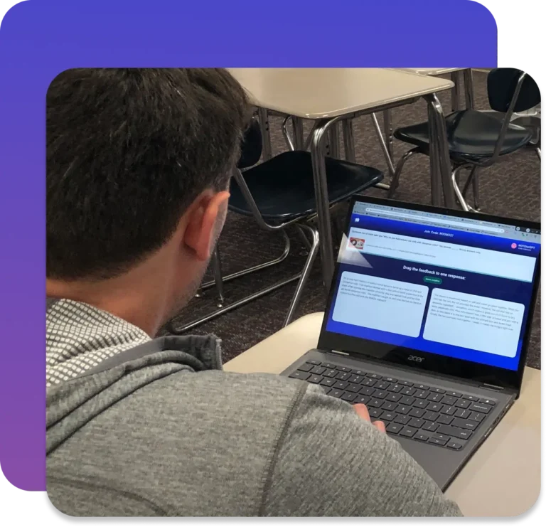 A man working on a computer on which he is comparing two student responses